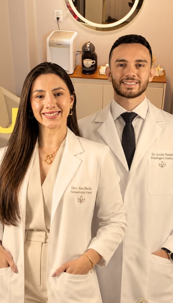 Dra. Ana Paula Stefanczak e Dr. Lucas Panato de jaleco na clínica